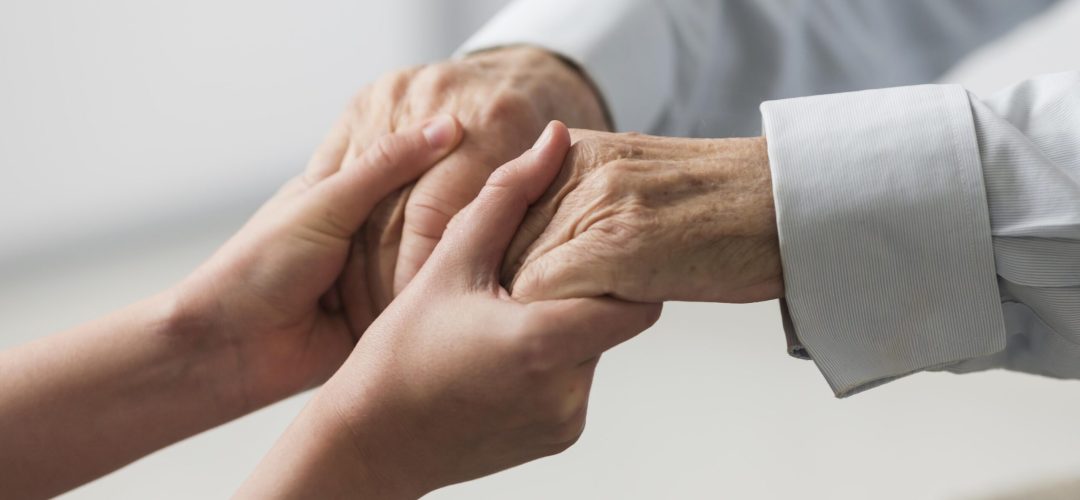 enfermeira-segurando-as-maos-de-um-homem-senior-por-simpatia